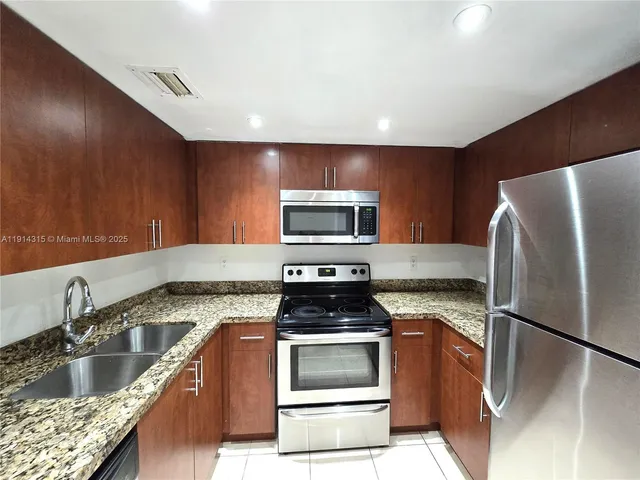 a kitchen with stainless steel appliances granite countertop a stove and a refrigerator