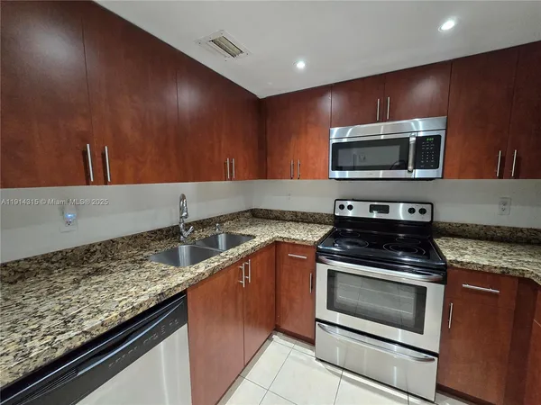 a kitchen with granite countertop stainless steel appliances and cabinets