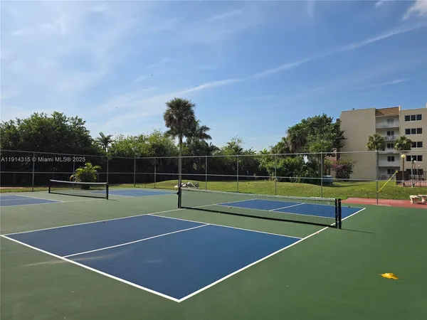 a view of tennis court with houses in the background