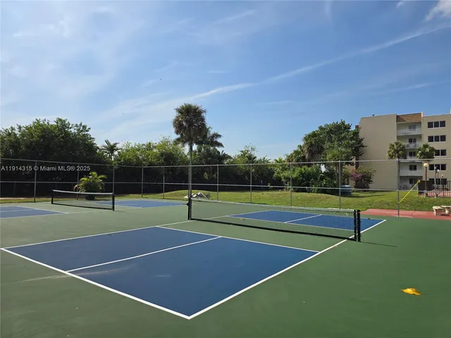 a view of tennis court with houses in the background
