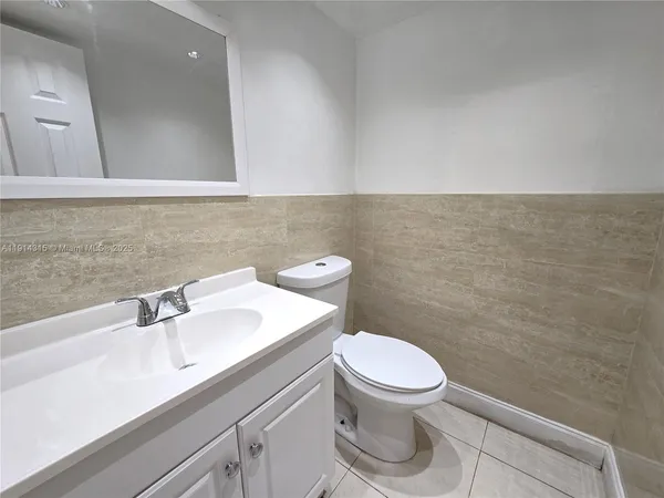 a bathroom with a toilet a sink and mirror