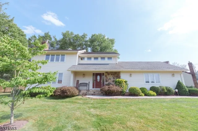 a view of a house with a yard and potted plants