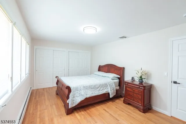 a bedroom with a bed and wooden floor