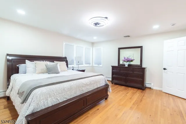 a bedroom with bed and wooden floor