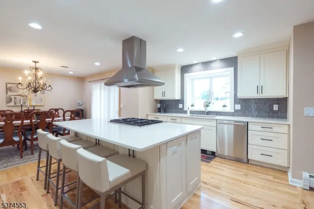 a kitchen with a stove a sink cabinets and wooden floor