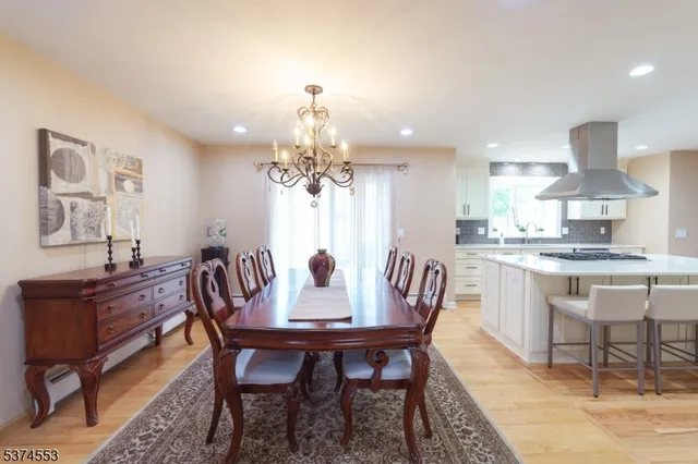 a dining room with furniture a chandelier and wooden floor