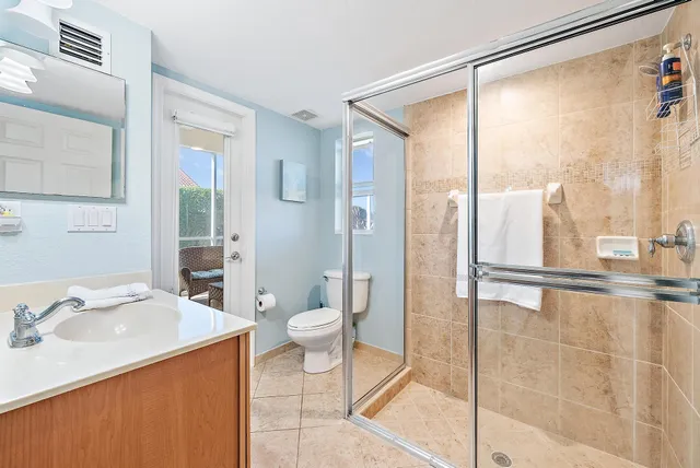 a bathroom with a granite countertop sink toilet and shower