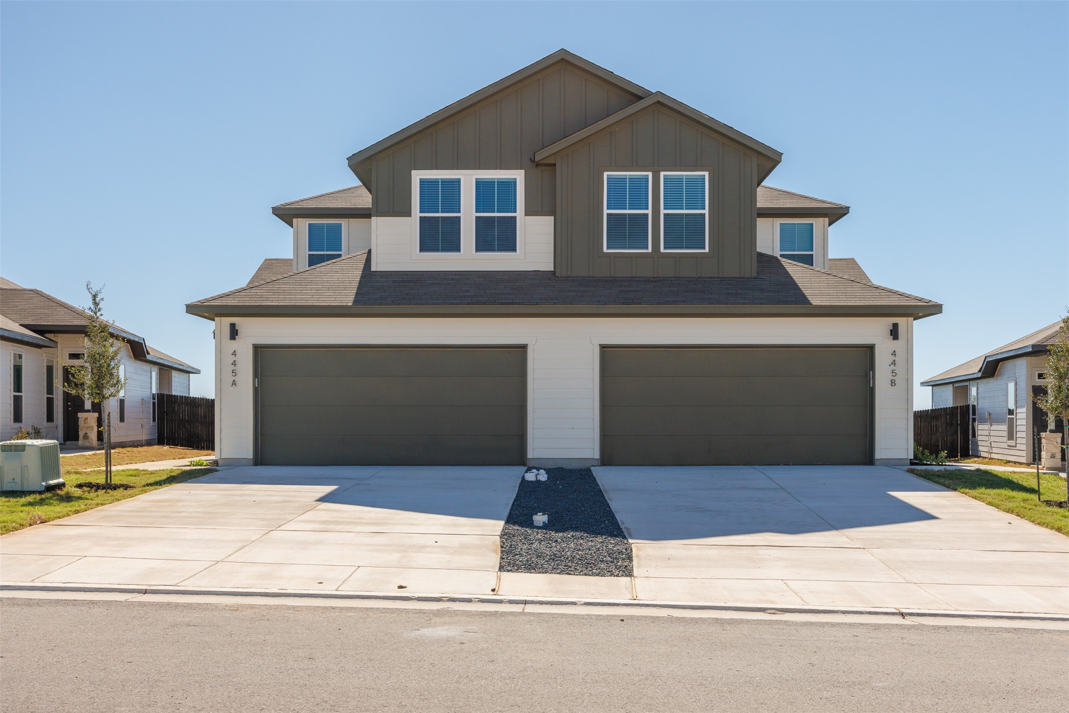 a front view of a house with yard and parking