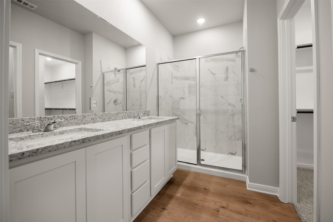 445 Cross Barn Boulevard, Unit B Buda, TX 78610 - Photo 10 of 18 a bathroom with a granite countertop sink mirror and double