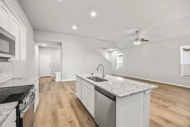 a bathroom with a granite countertop sink a toilet and shower