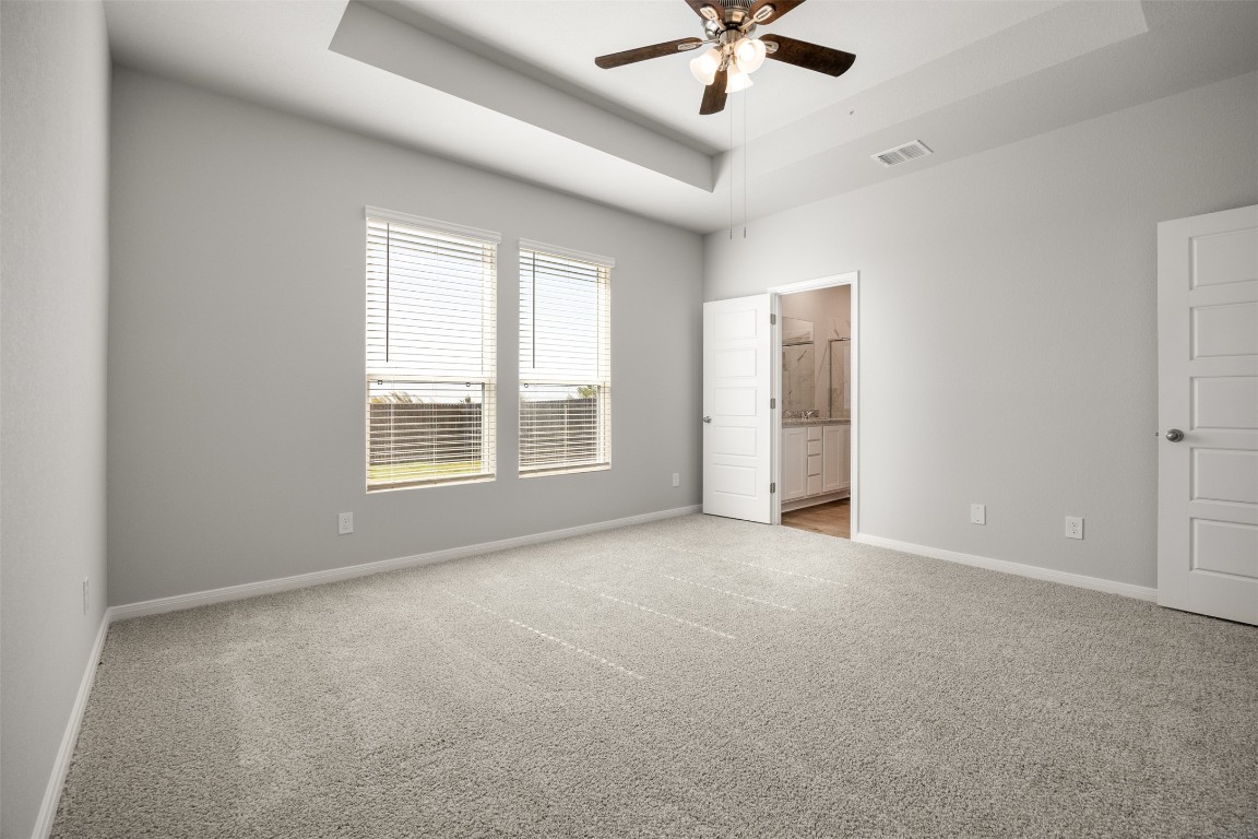 445 Cross Barn Boulevard, Unit B Buda, TX 78610 - Photo 9 of 18 an empty room with chandelier fan and windows