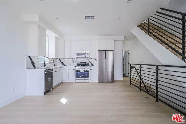 a kitchen with refrigerator and cabinets