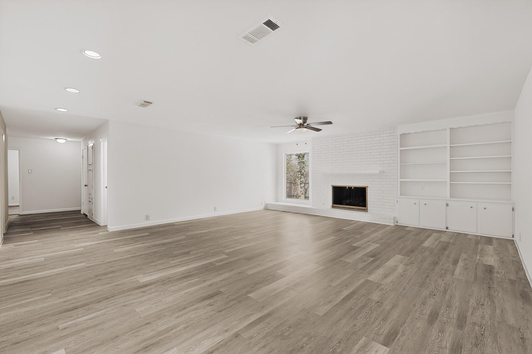 812 George Street Taylor, TX 76574 - Photo 7 of 34 Unfurnished living room featuring a fireplace, light wood finished floors, a ceiling fan, built in shelves, and recessed lighting