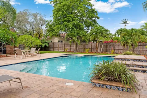 a view of swimming pool with lounge chair and dinning table under an umbrella