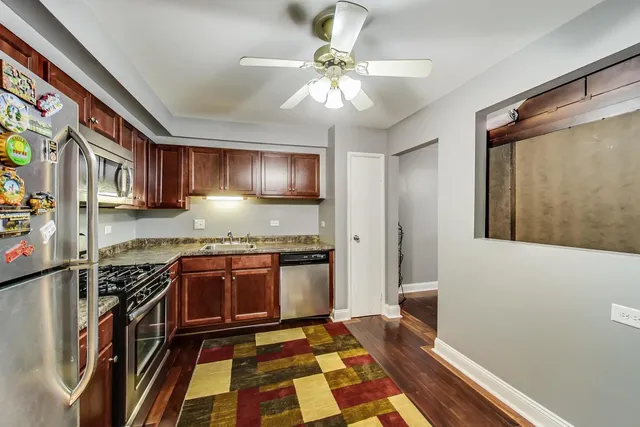 a kitchen with stainless steel appliances granite countertop a stove top oven a sink and dishwasher