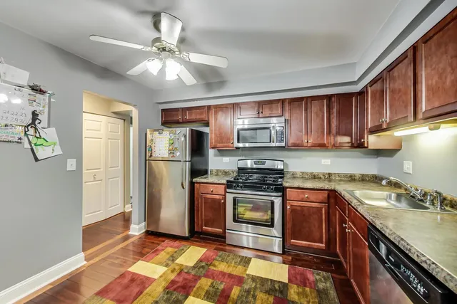a kitchen with stainless steel appliances granite countertop a stove refrigerator sink and microwave