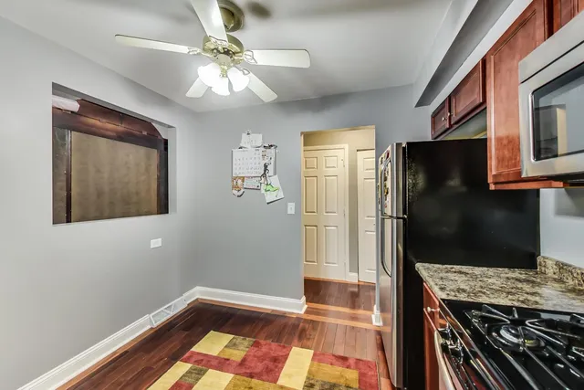 a kitchen with a refrigerator and a stove top oven