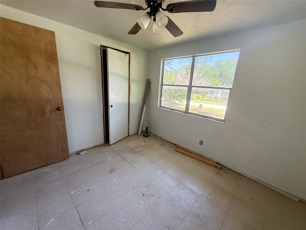 116 5th Street Whitney, TX 76692 - Photo 18 of 23 an empty room with a window and a fan