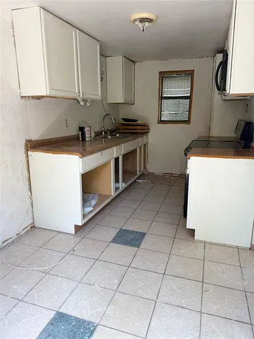 a kitchen with stainless steel appliances a stove a microwave a sink a counter top space and cabinets