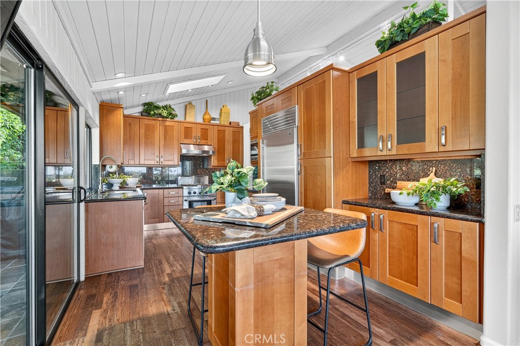 30 Nuevo, Unit 15 Irvine, CA 92612 - Photo 21 of 69 a dining room with stainless steel appliances granite countertop a refrigerator a stove a sink dishwasher and white cabinets with wooden floor