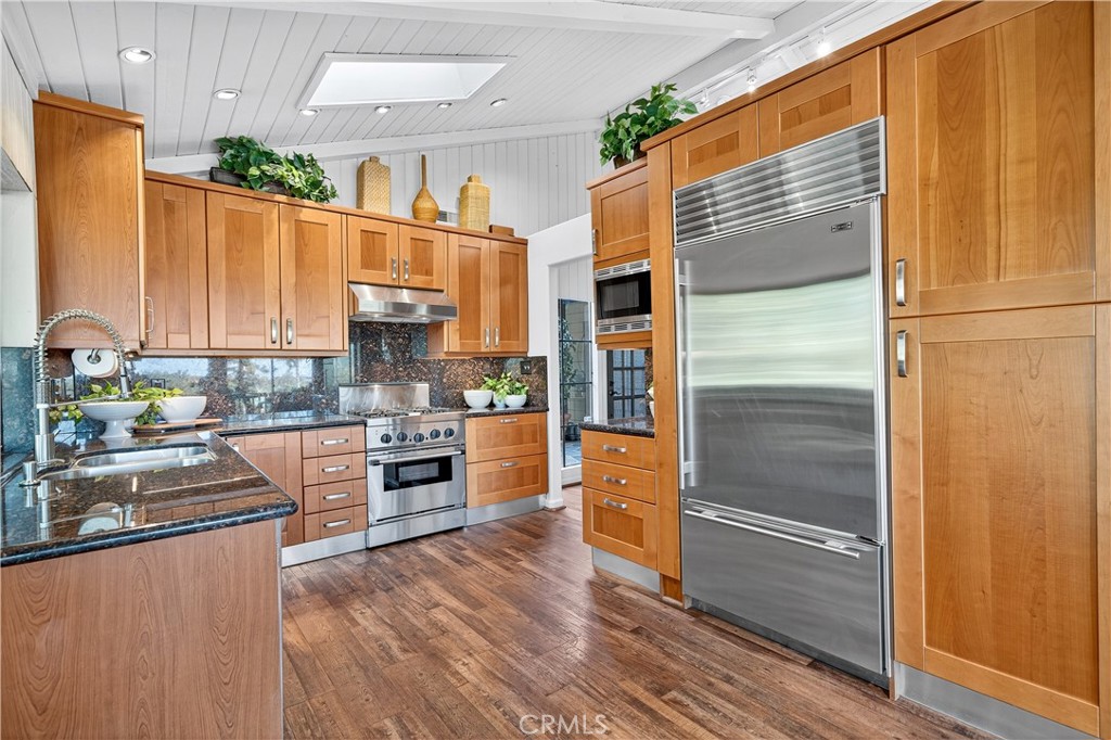30 Nuevo, Unit 15 Irvine, CA 92612 - Photo 22 of 69 a kitchen with stainless steel appliances granite countertop a refrigerator a oven a sink and dishwasher with wooden floor