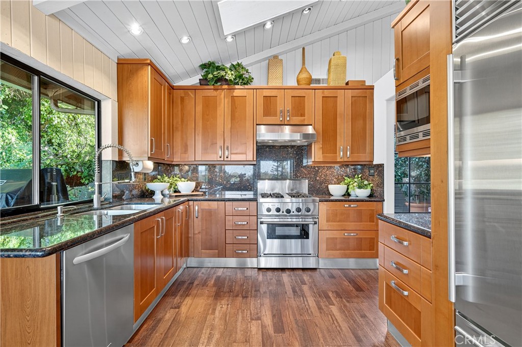 30 Nuevo, Unit 15 Irvine, CA 92612 - Photo 24 of 69 a kitchen with stainless steel appliances wooden floors and wooden cabinets
