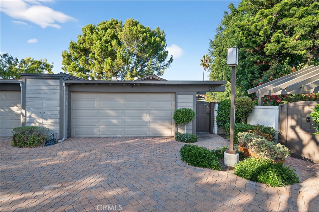 30 Nuevo, Unit 15 Irvine, CA 92612 - Photo 3 of 69 a front view of a house with a yard and potted plants