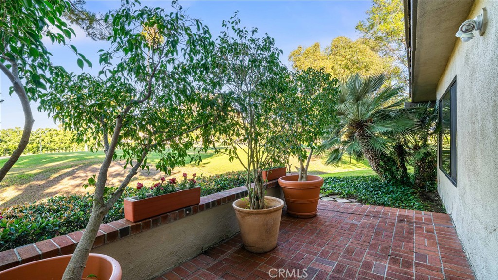 30 Nuevo, Unit 15 Irvine, CA 92612 - Photo 35 of 69 a backyard of a house with fountain plants and large tree
