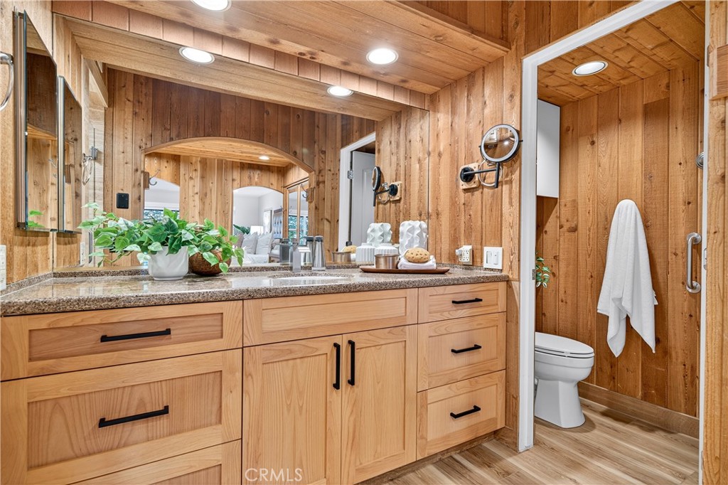 30 Nuevo, Unit 15 Irvine, CA 92612 - Photo 42 of 69 a bathroom with a granite countertop sink a toilet a mirror and shower