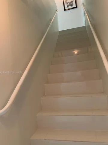 a bedroom with a bed and a lamp on dresser