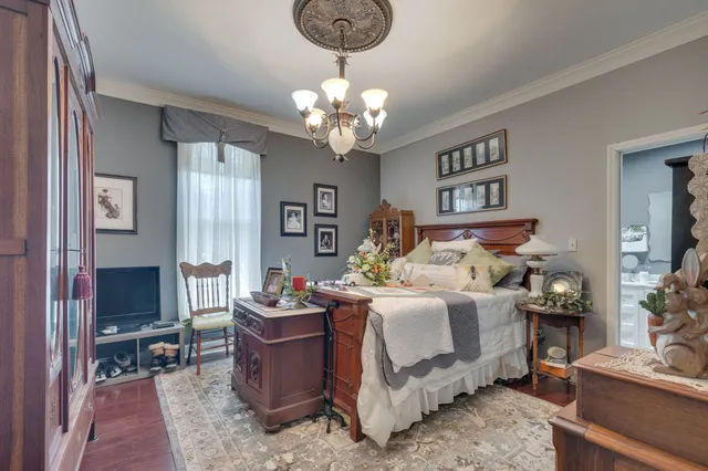 a bedroom with bed a chandelier and a window