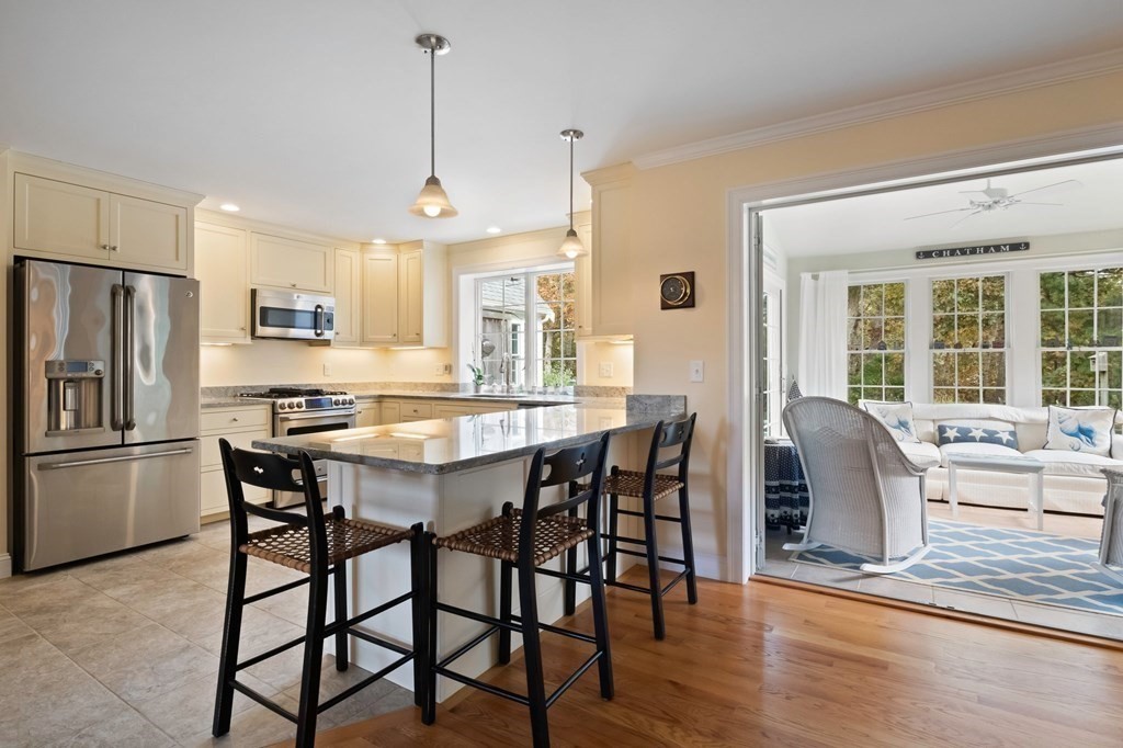 100 Round Cove Road Chatham, MA 02633 - Photo 7 of 38 a dining room with stainless steel appliances granite countertop a dining table chairs refrigerator and microwave