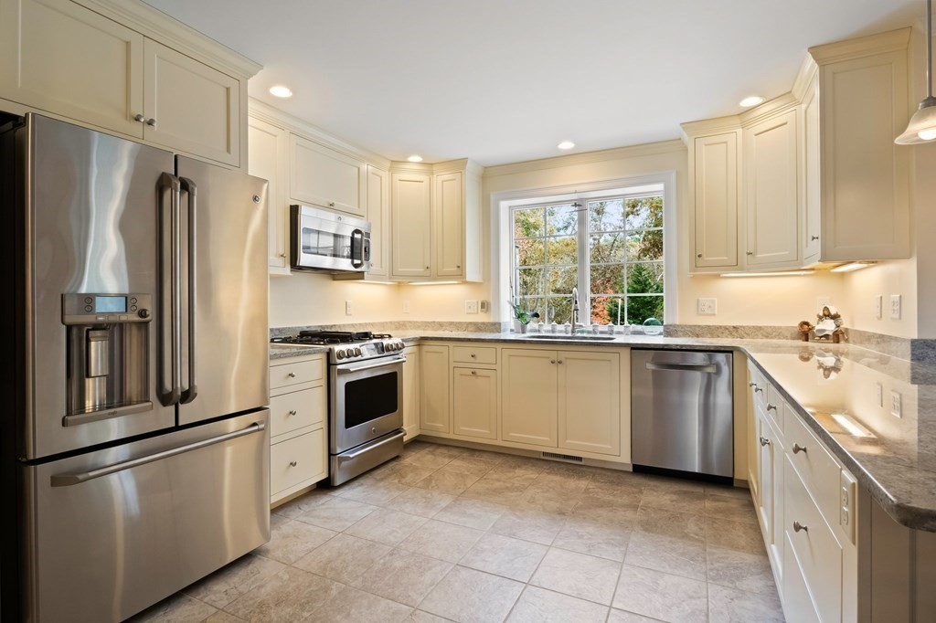 100 Round Cove Road Chatham, MA 02633 - Photo 8 of 38 a kitchen with stainless steel appliances granite countertop a refrigerator a sink a stove and white cabinets