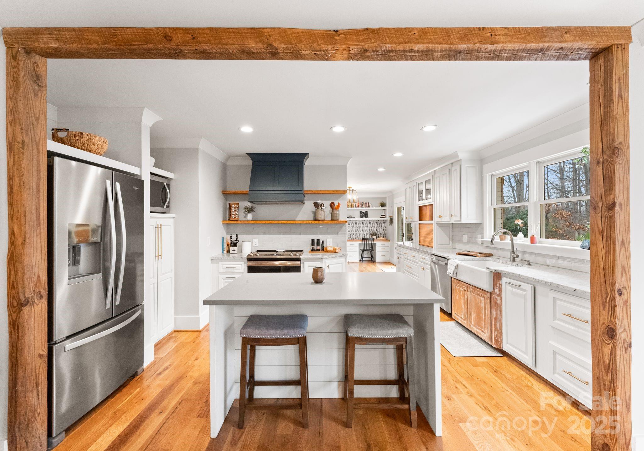 2550 Green Point Court Denver, NC 28037 - Photo 9 of 42 a kitchen with stainless steel appliances a refrigerator a stove a sink dishwasher and a dining table with wooden floor