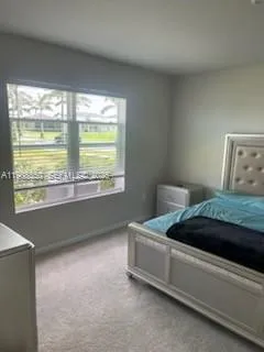 a bed sitting in a bedroom next to a window