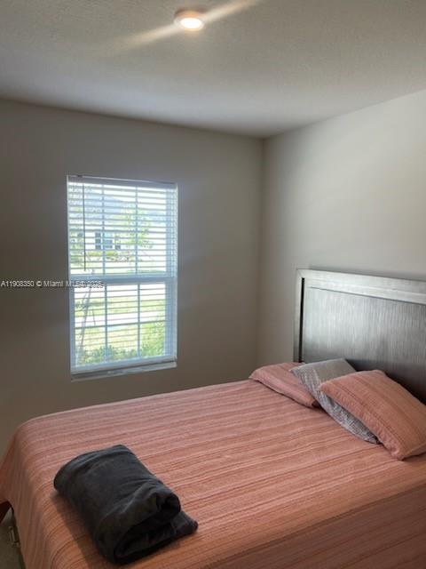 9509 Southwest Libertas Way, Unit : Port St. Lucie, FL 34987 - Photo 12 of 16 a bedroom with a bed and a window