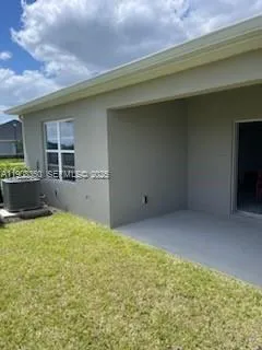 a view of an empty room with kitchen and a window