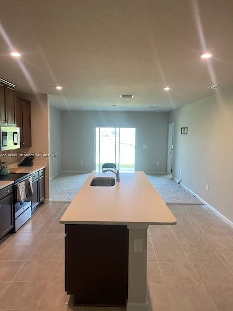 9509 Southwest Libertas Way, Unit : Port St. Lucie, FL 34987 - Photo 3 of 16 a open kitchen with stainless steel appliances kitchen island a sink dishwasher a stove and a refrigerator with wooden floor