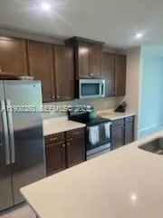 a kitchen with stainless steel appliances a sink stove and refrigerator