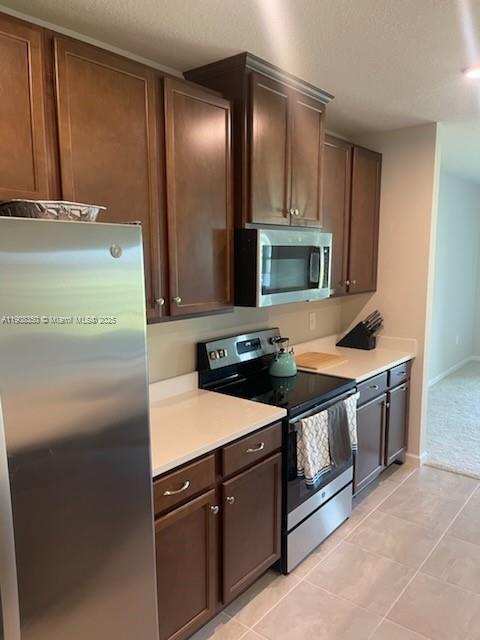 9509 Southwest Libertas Way, Unit : Port St. Lucie, FL 34987 - Photo 6 of 16 a kitchen with stainless steel appliances granite countertop a stove a sink and a refrigerator