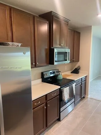 a kitchen with stainless steel appliances granite countertop a refrigerator and a stove
