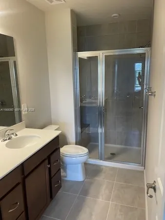 a bathroom with a shower sink vanity and toilet