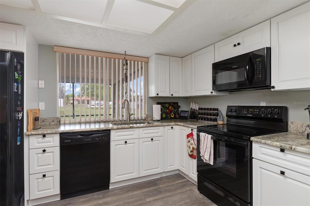 23226 Midway Boulevard Punta Gorda, FL 33980 - Photo 13 of 37 a kitchen with stainless steel appliances granite countertop a stove a sink and a microwave