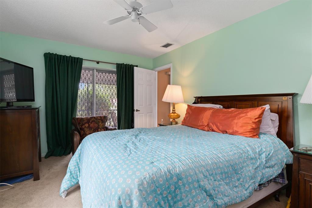 23226 Midway Boulevard Punta Gorda, FL 33980 - Photo 16 of 37 a bedroom with a large bed and a tv