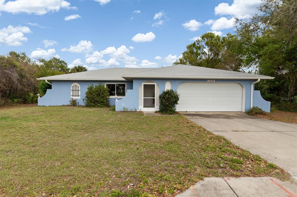 23226 Midway Boulevard Punta Gorda, FL 33980 - Photo 28 of 37 a front view of house with yard and trees in the background