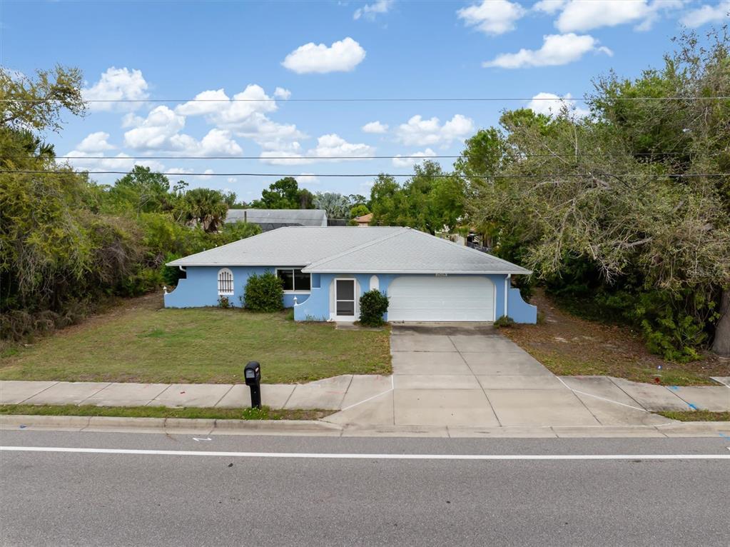 23226 Midway Boulevard Punta Gorda, FL 33980 - Photo 29 of 37 a front view of a house with a yard and garage