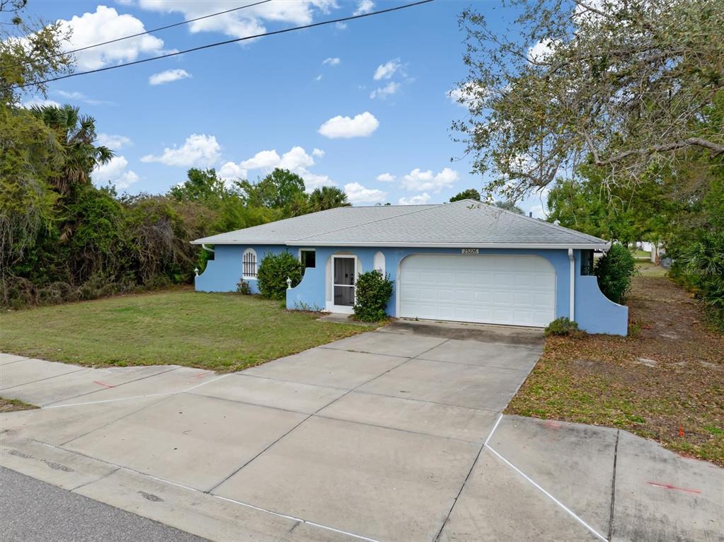 23226 Midway Boulevard Punta Gorda, FL 33980 - Photo 31 of 37 a front view of house with yard garage and green space