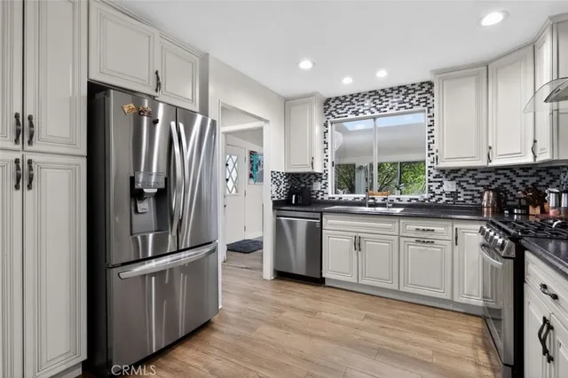 a kitchen with stainless steel appliances a stove a sink and a refrigerator