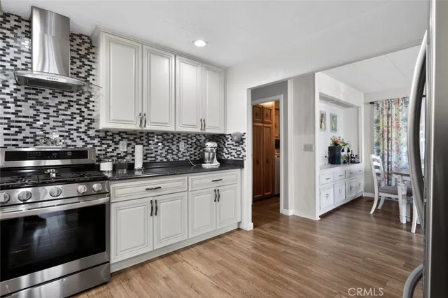 a kitchen with granite countertop a sink a stove and cabinets
