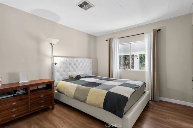 a bedroom with a bed and wooden floor